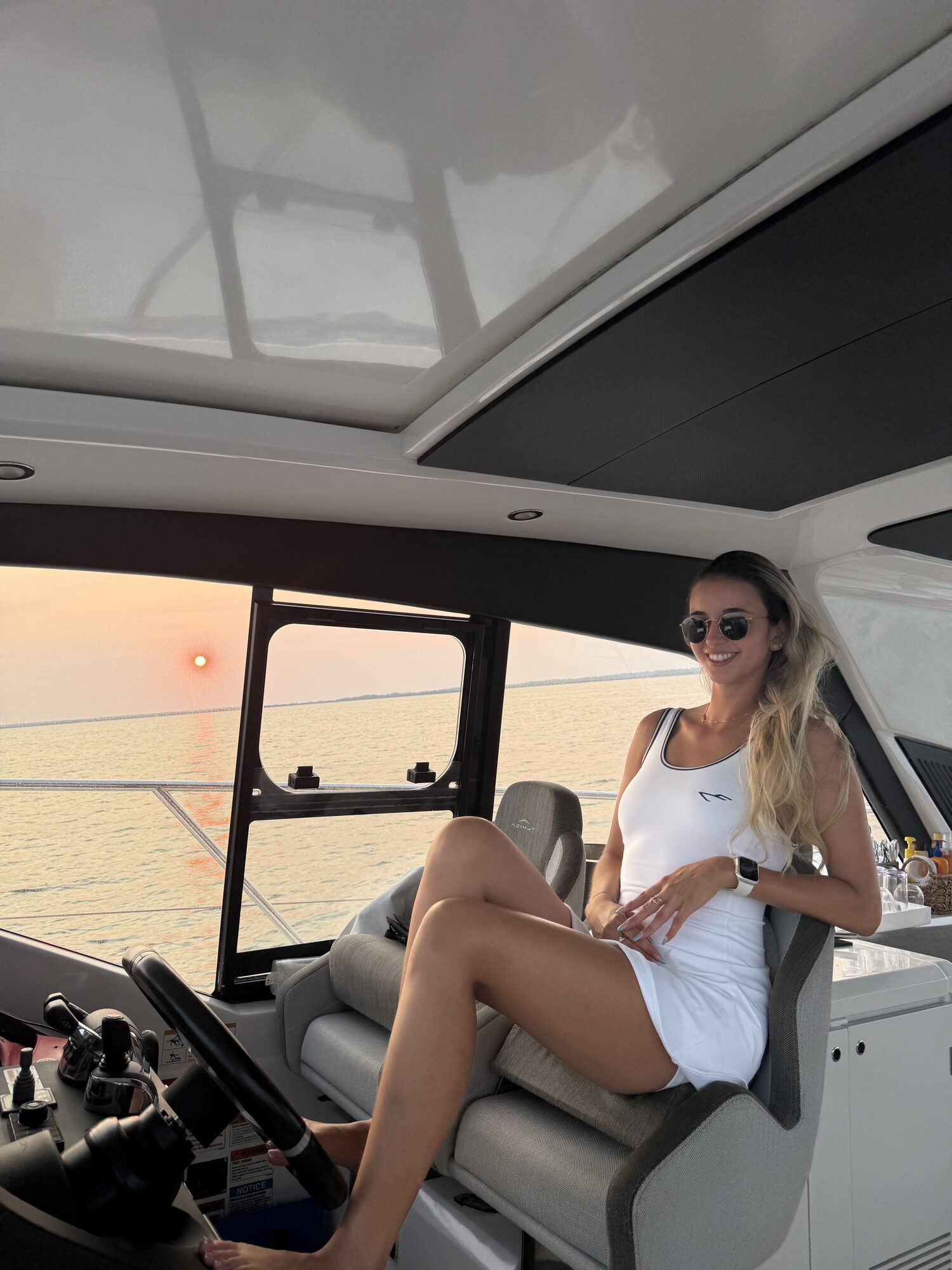Guest at the helm at sunset on a Hamptons charter