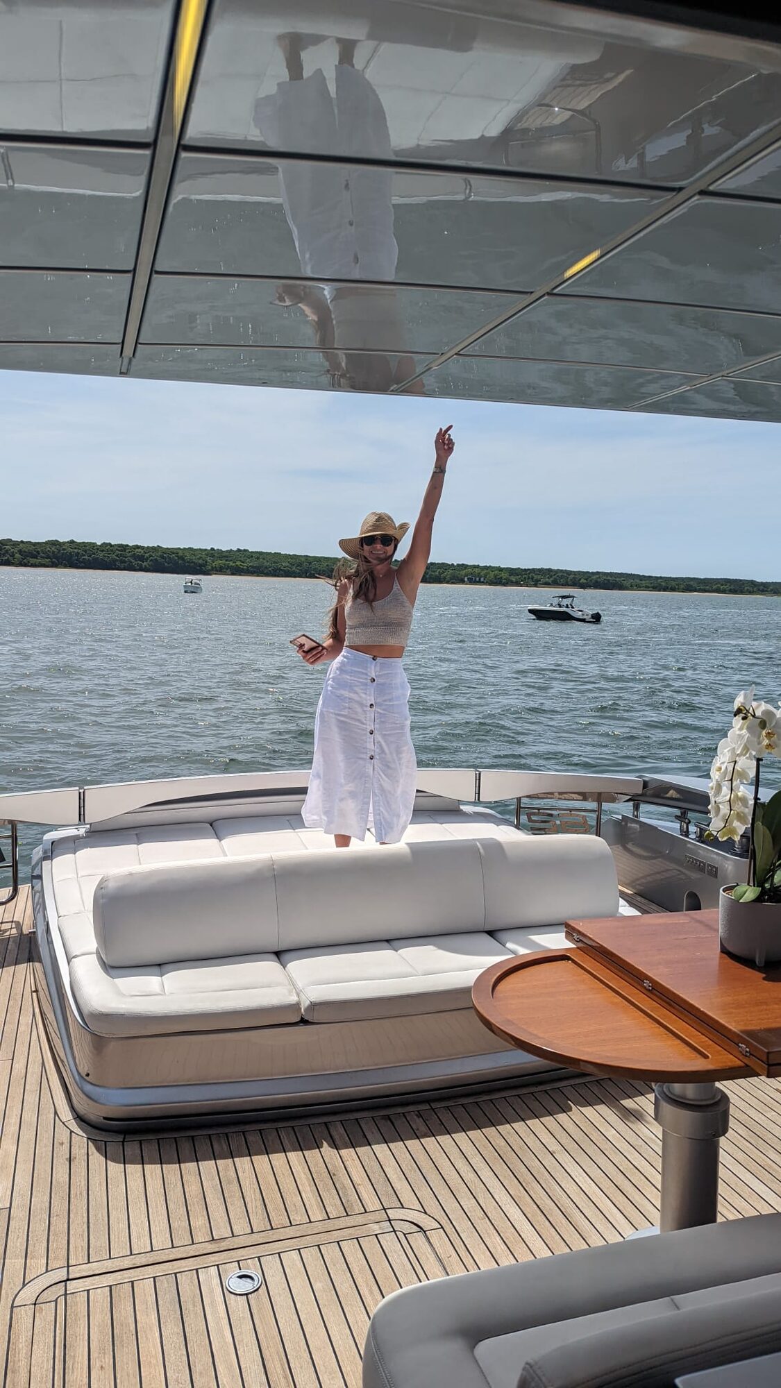 Guest celebrating on the foredeck of a Yacht Hampton charter at anchor in the Hamptons