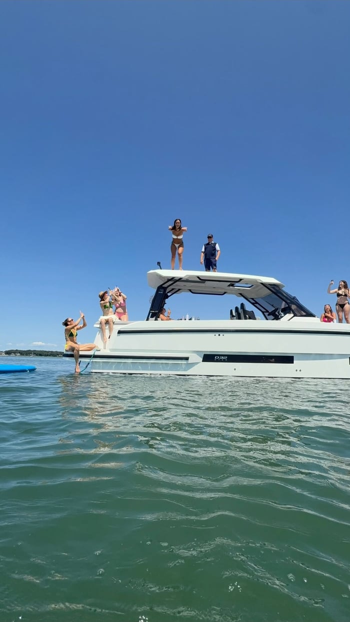 A charter anchored at a sandbar with guests swimming