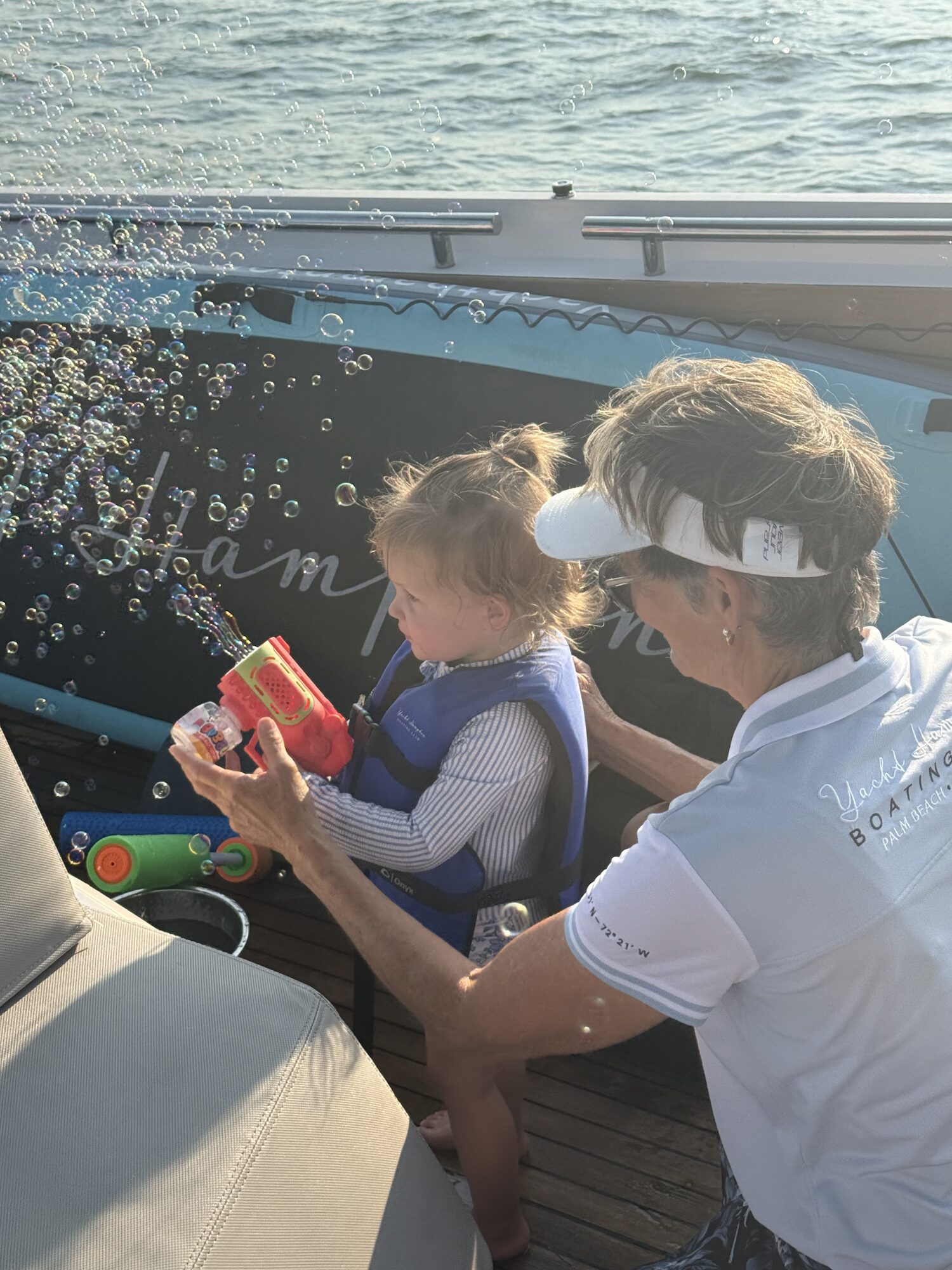 Crew member playing with a toddler on the swim platform during a Hamptons charter