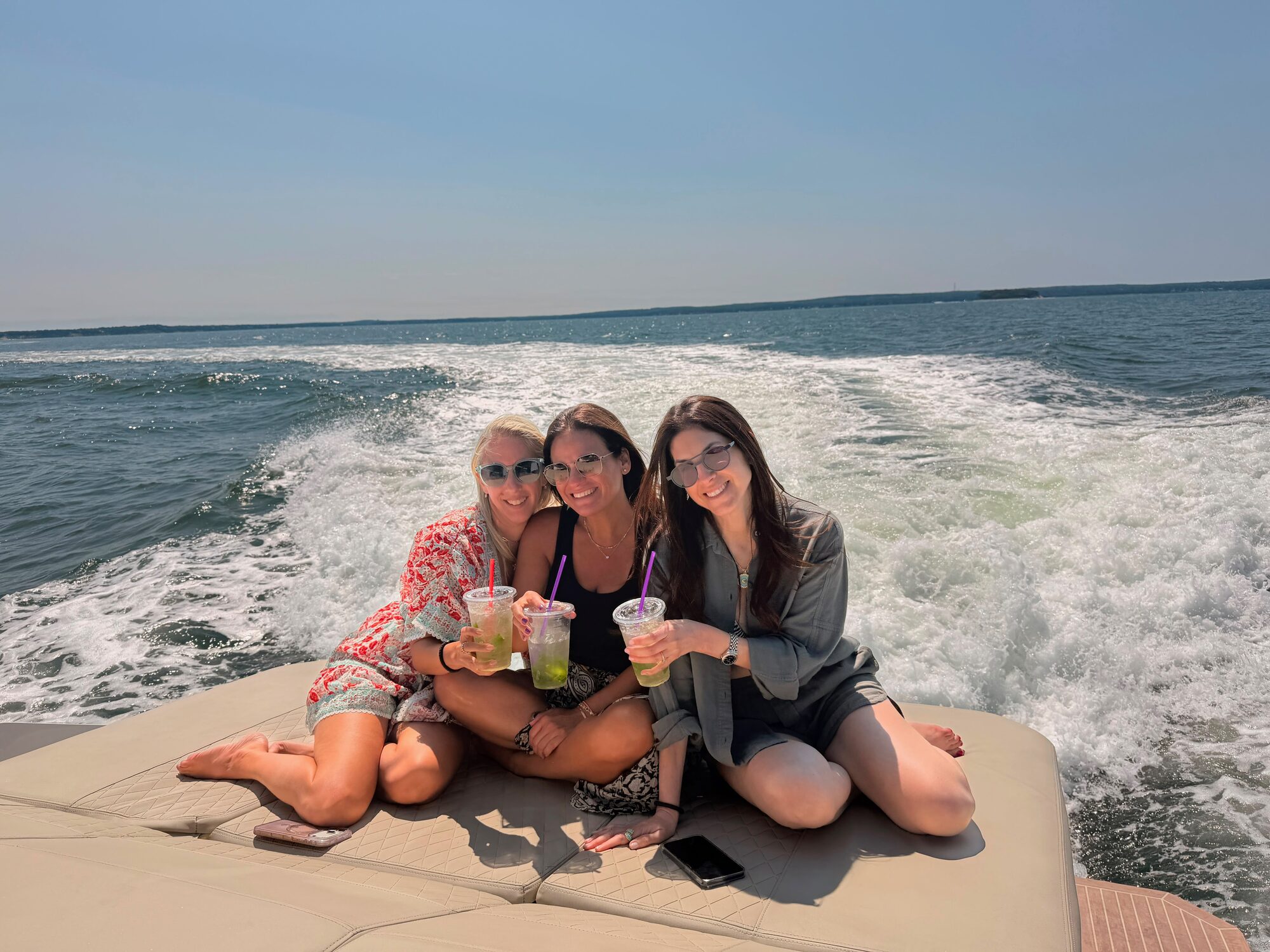 Friends with drinks on the aft sun pad underway