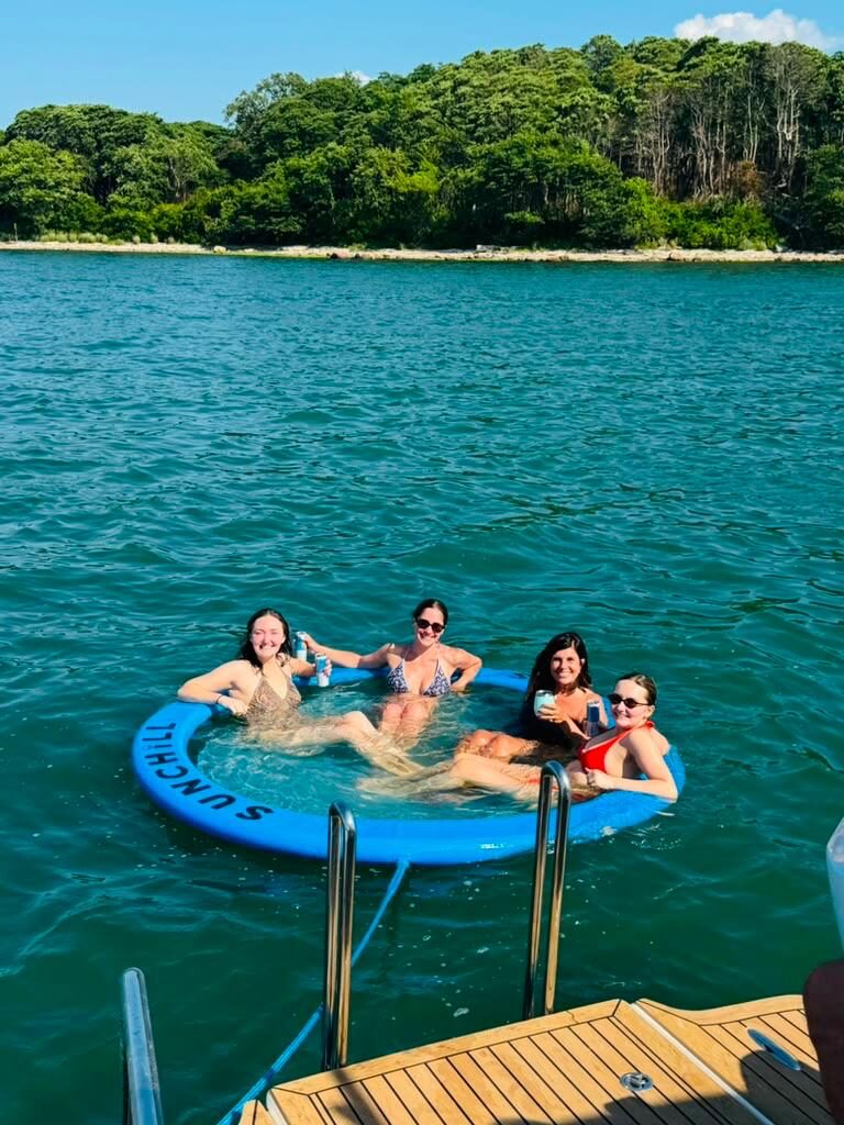 Guests floating in the ring off the swim platform in turquoise Hamptons water