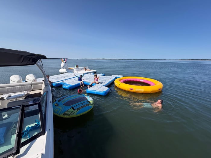 A floating dock rigged with water toys alongside a vessel