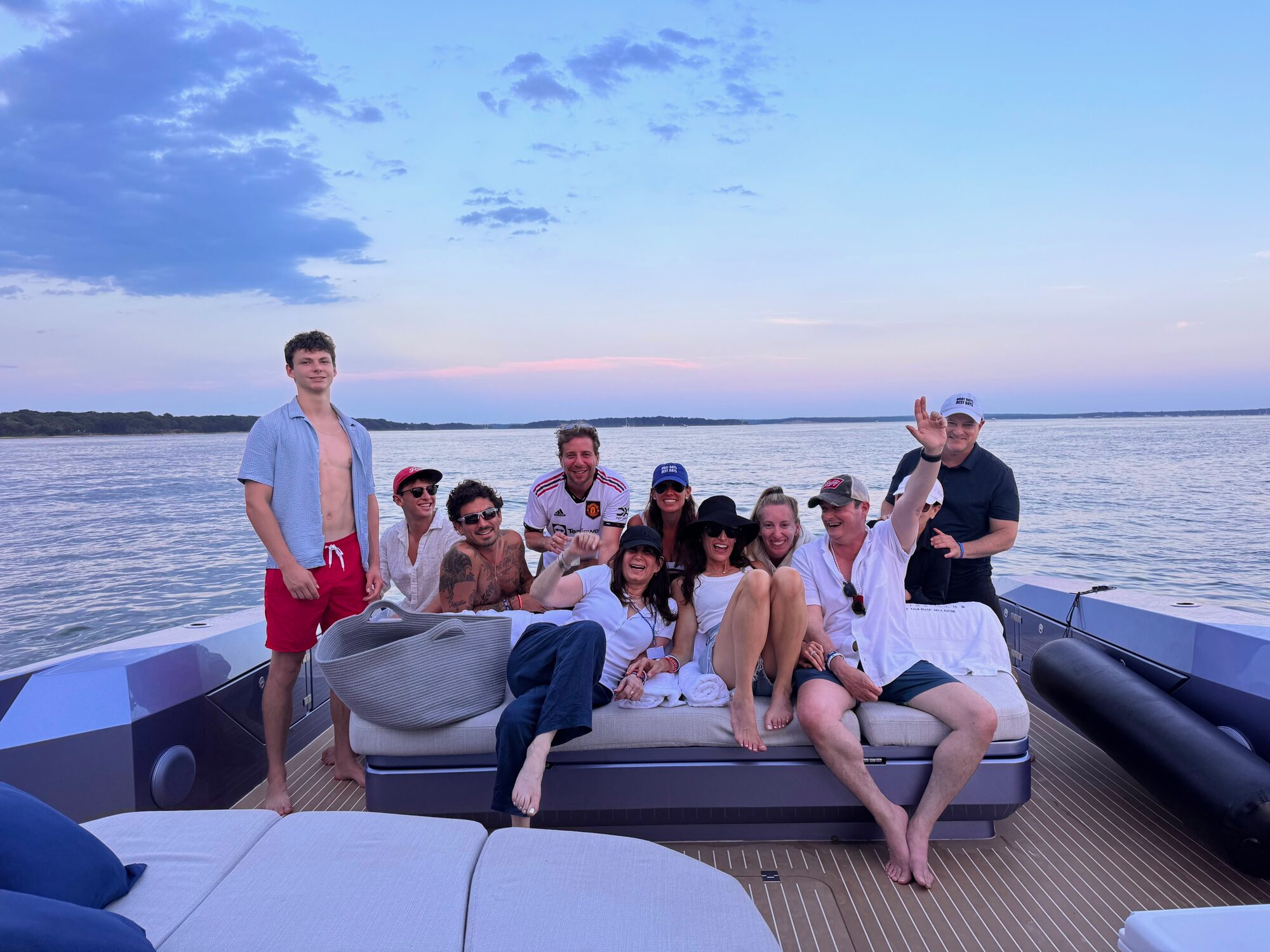 Friends gathered on the aft deck at dusk in the Hamptons