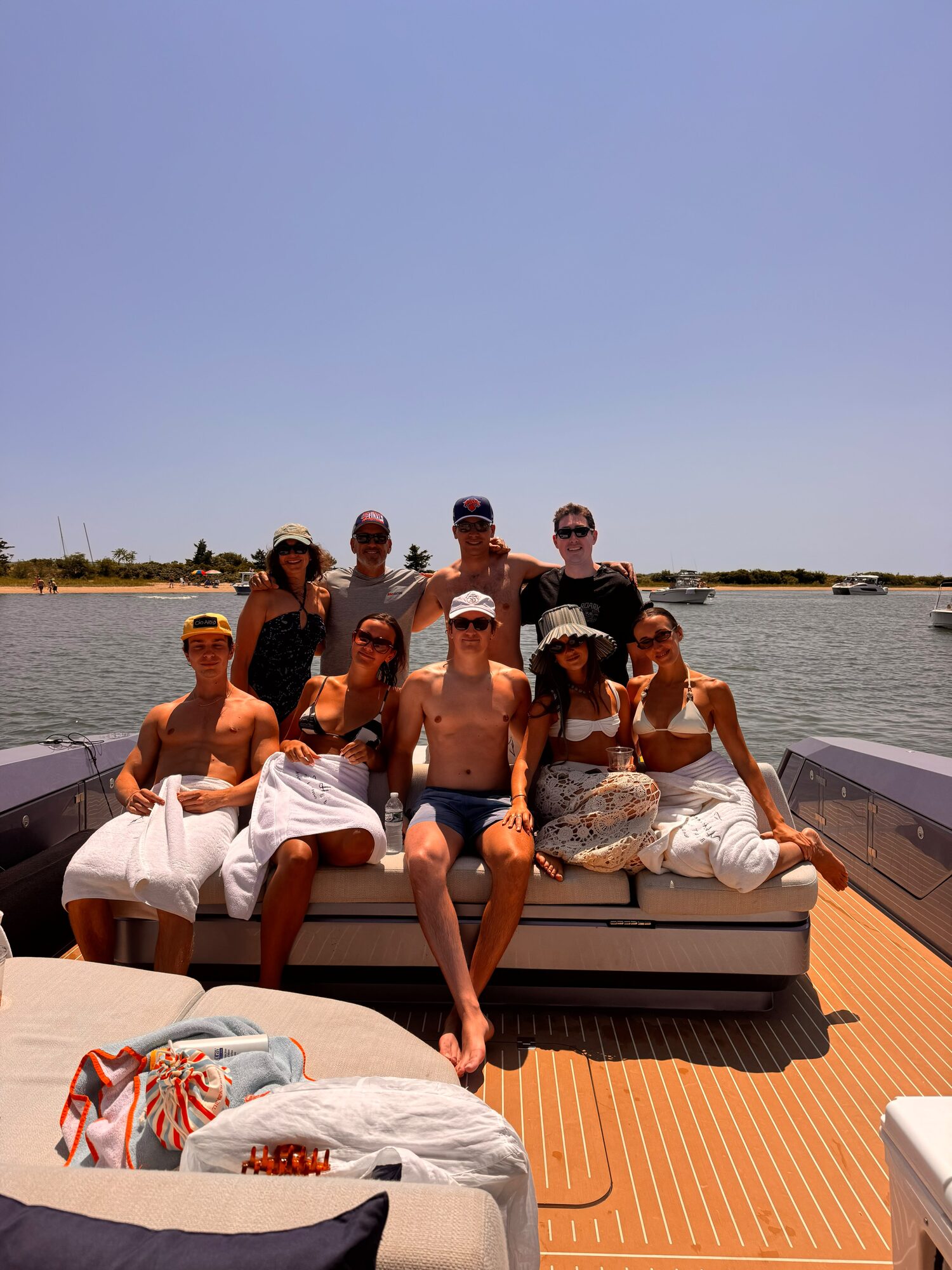 Friends soaking up the sun on the foredeck at a Hamptons sandbar