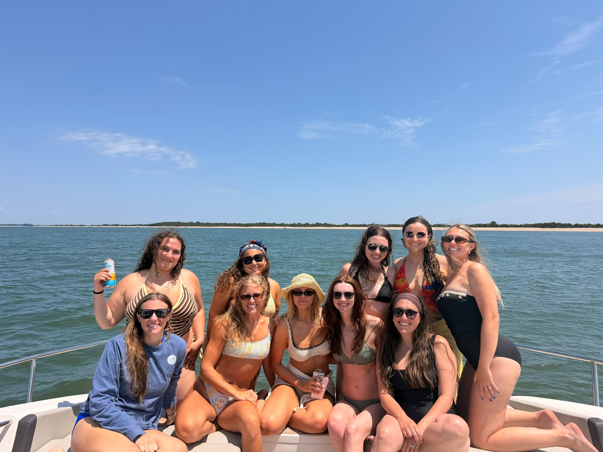Girls' trip gathered on the bow at a Hamptons sandbar