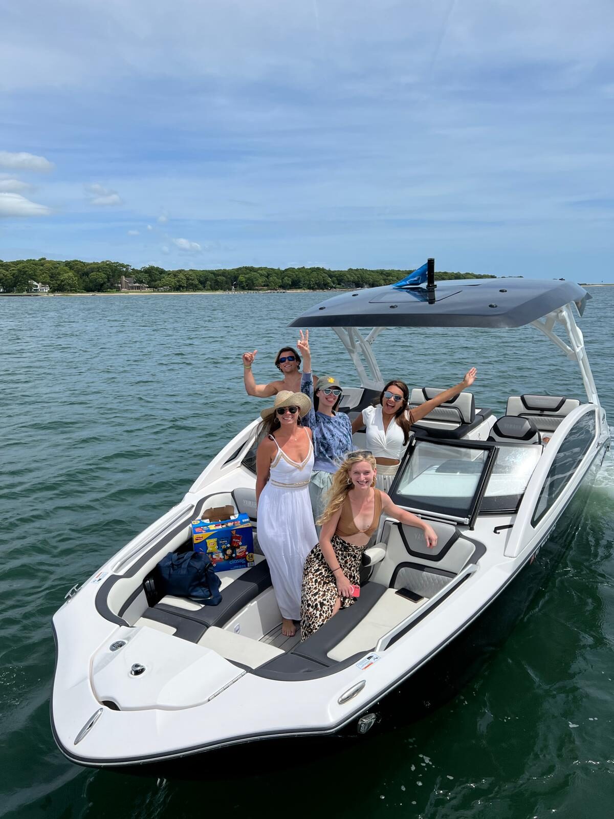 Group gathered on the bow of a Yacht Hampton wake boat at a Hamptons sandbar