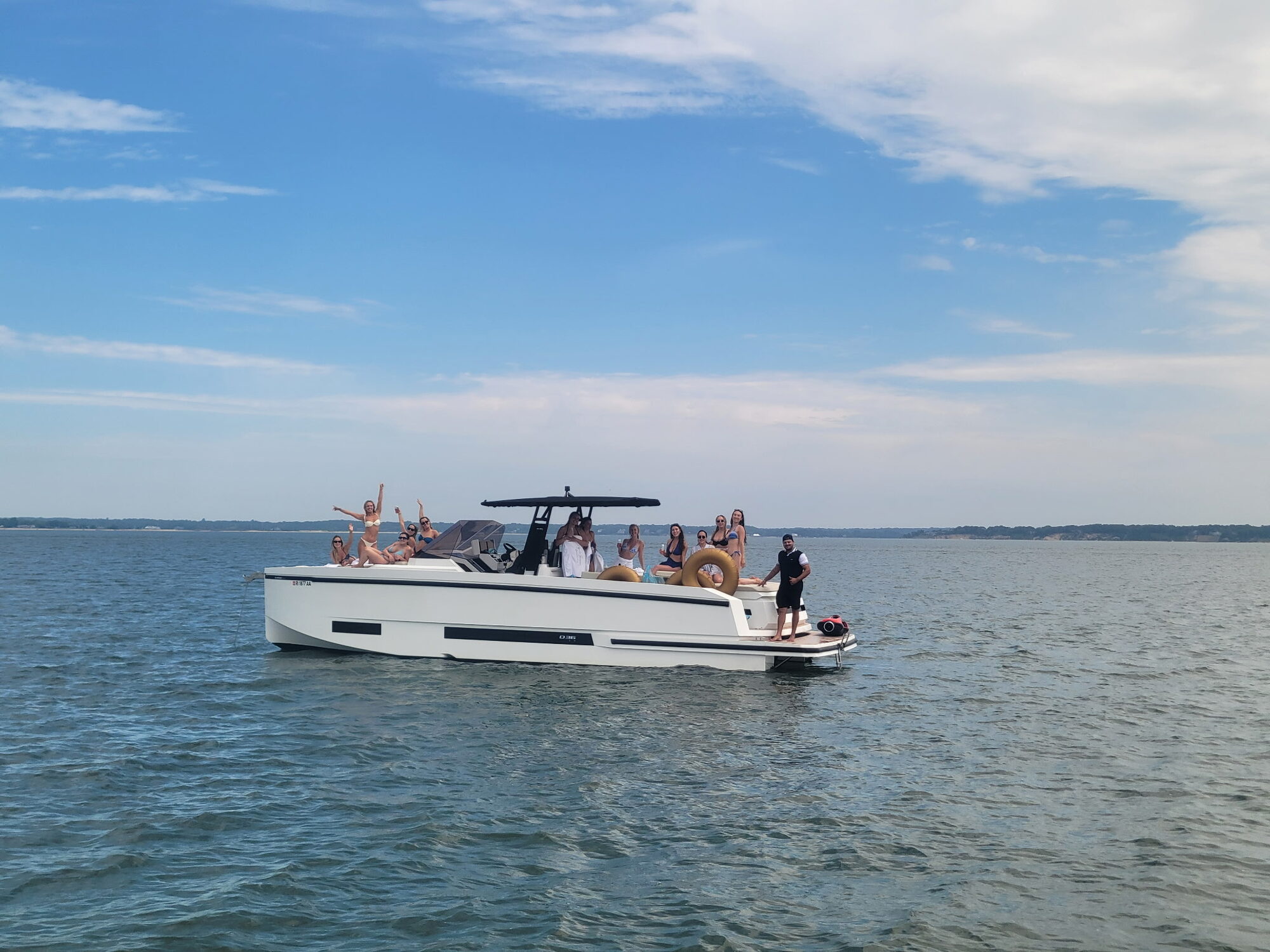 Guests waving from a Yacht Hampton charter cruising the Hamptons