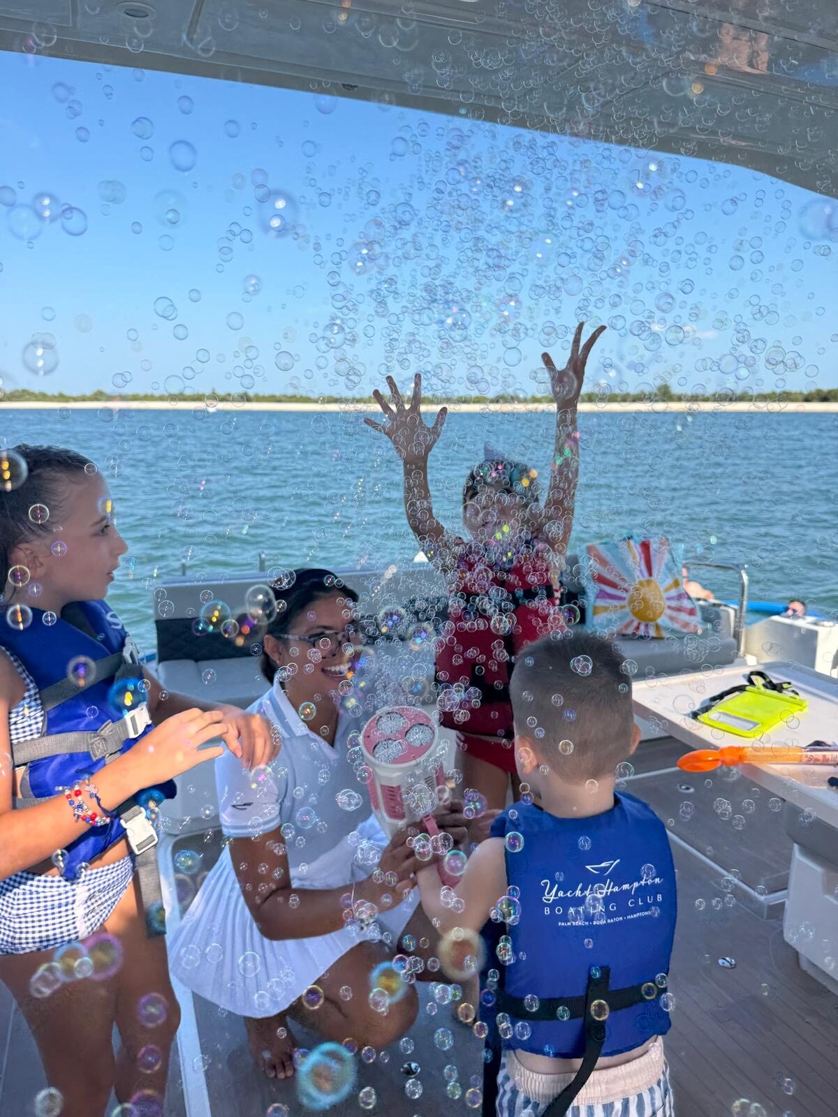 Kids and bubbles on deck in Yacht Hampton Boating Club life vests