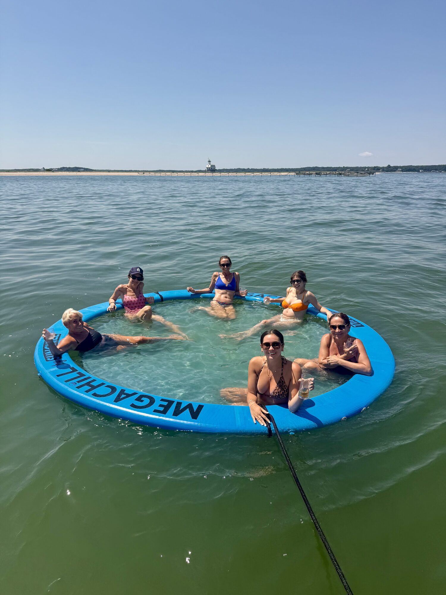 Guests floating in the MegaChill ring at a Hamptons sandbar