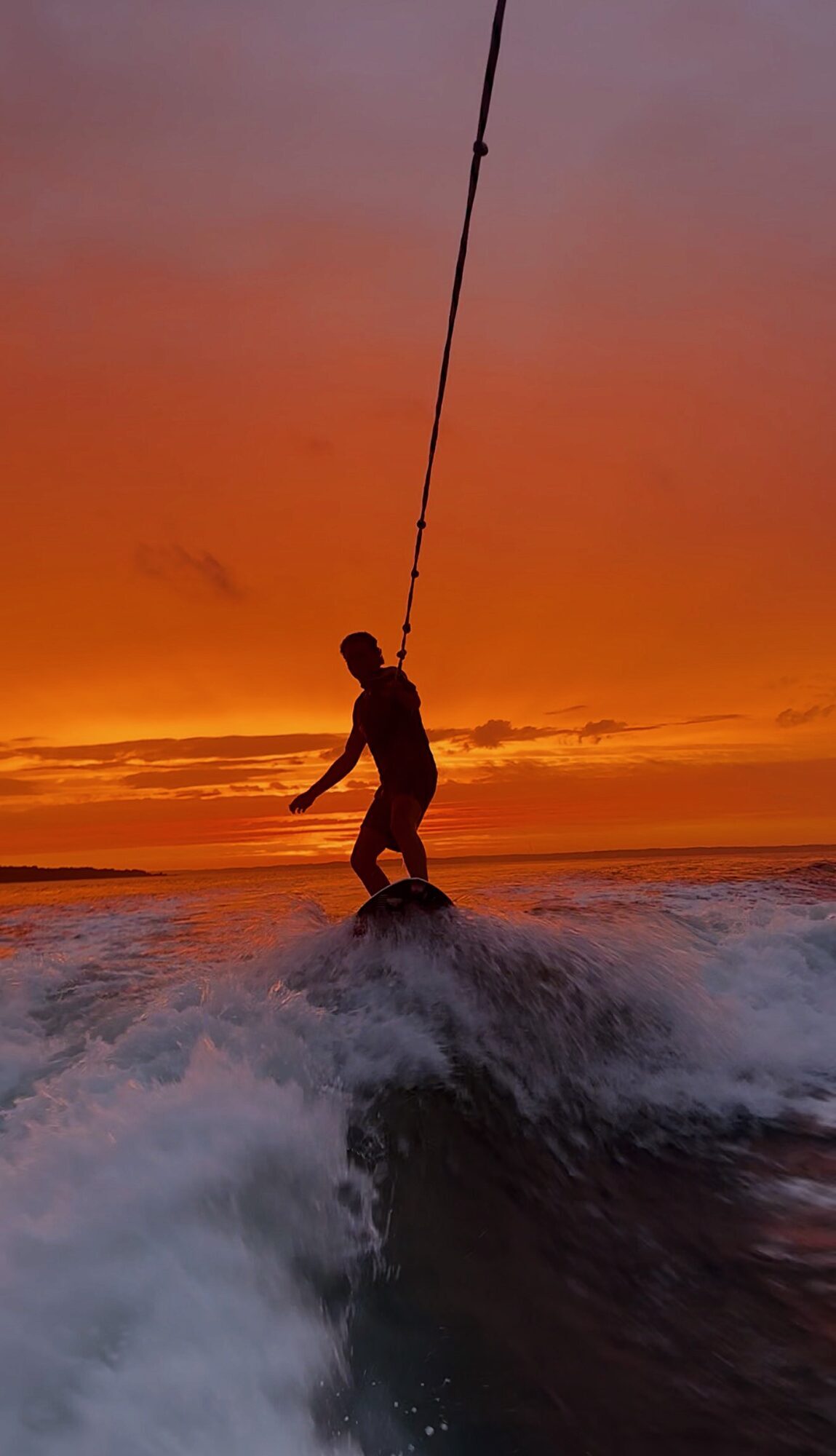Wakesurfing behind the boat at sunset in the Hamptons