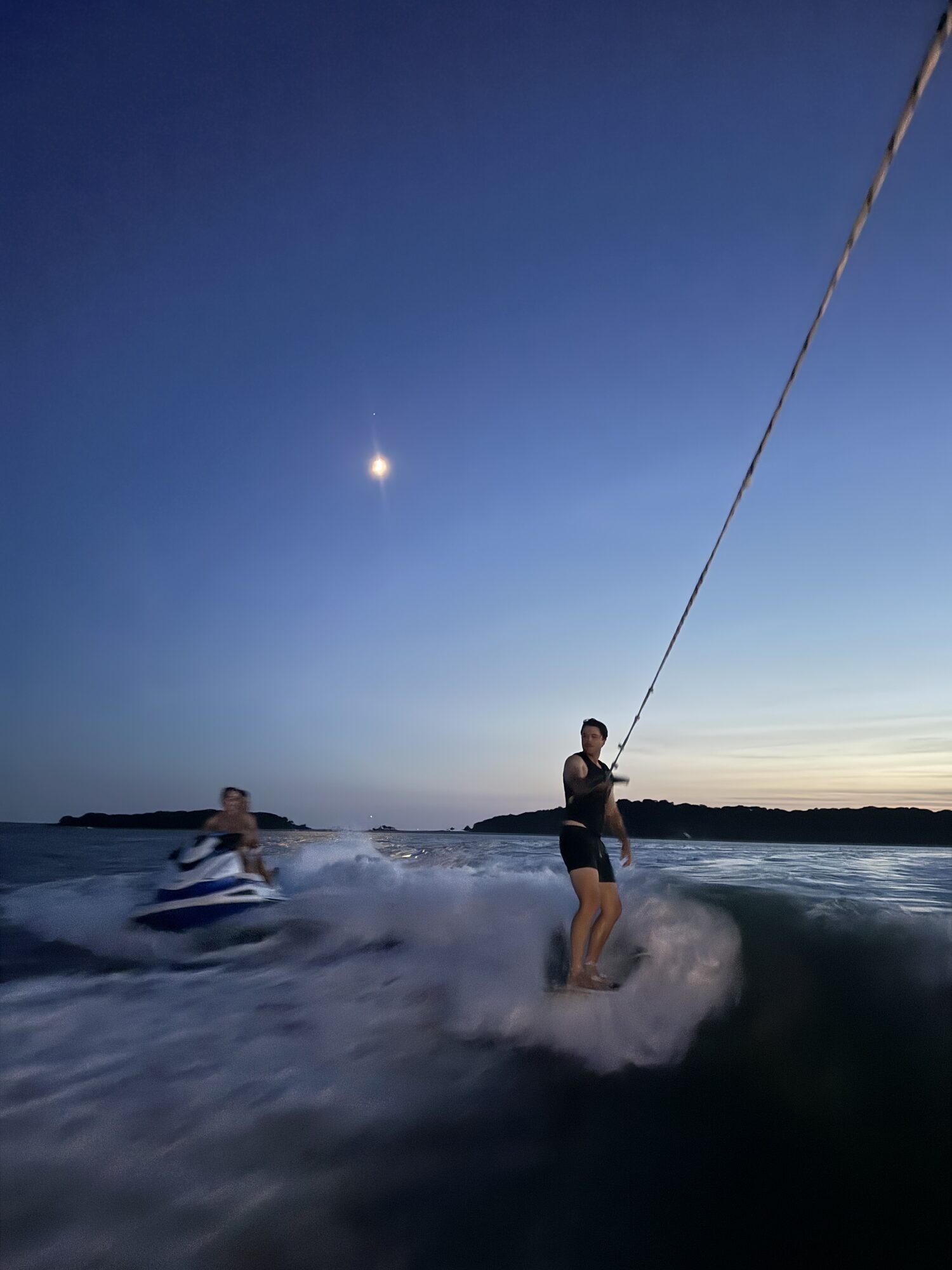 Wakesurfing under the moon at dusk in the Hamptons