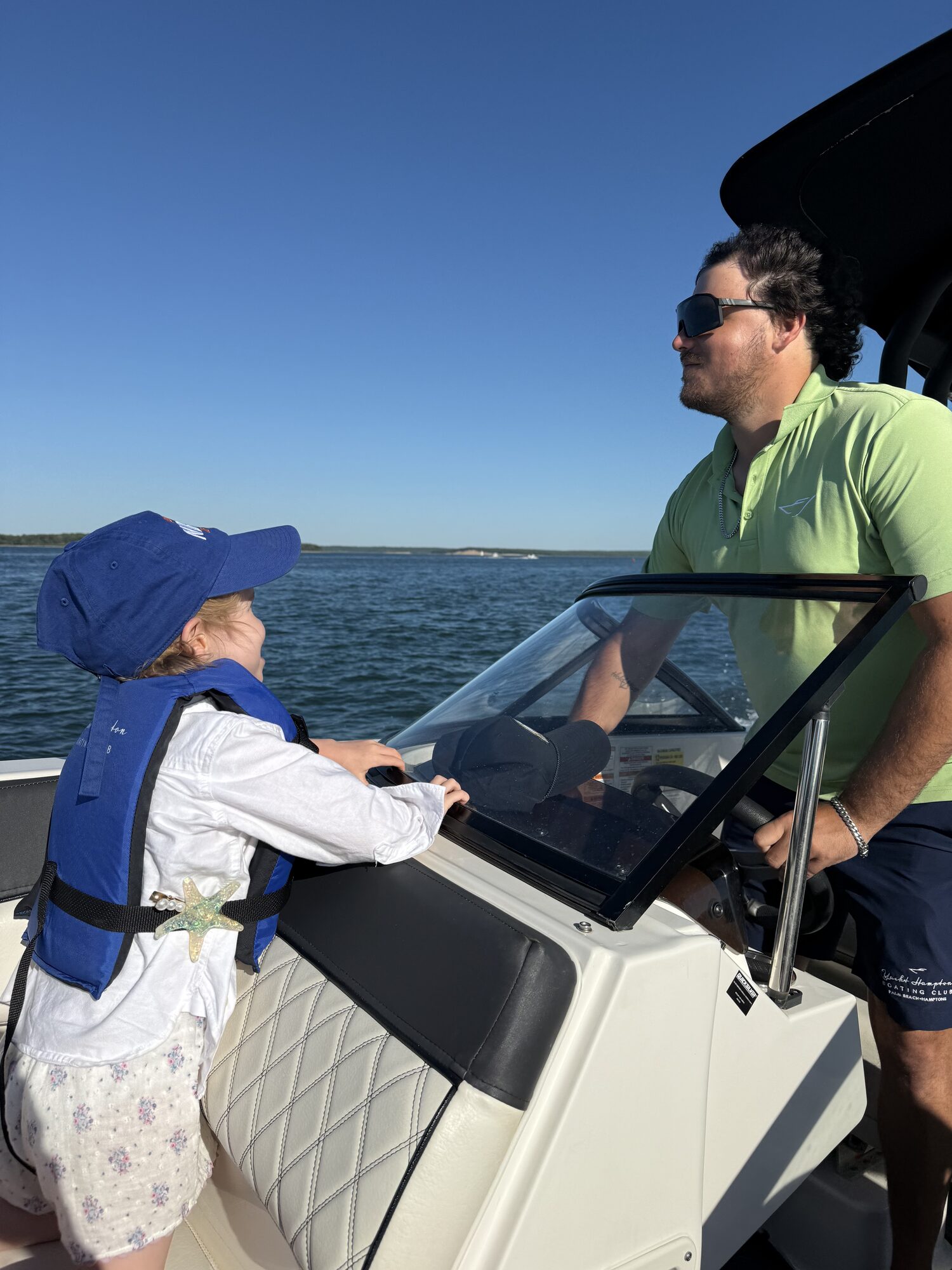 Young guest taking the helm alongside the captain