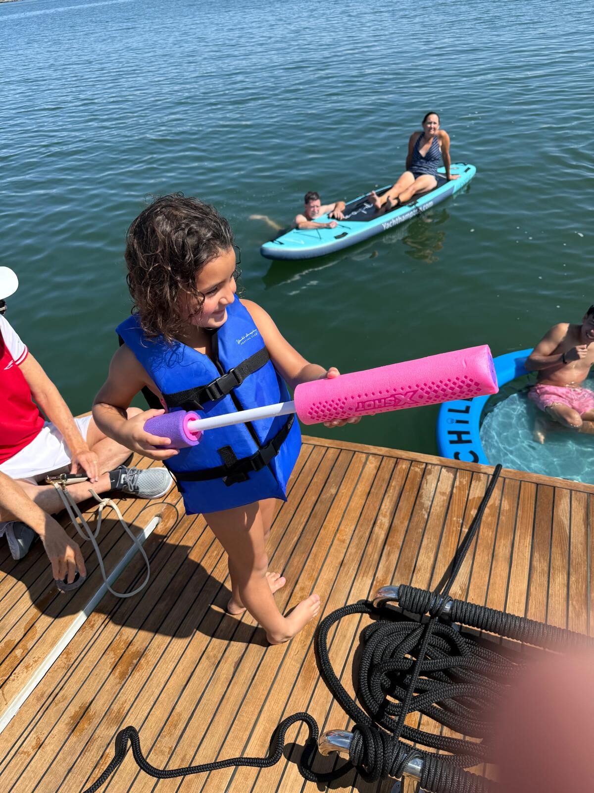 Young guest on the swim platform with paddleboards out at the sandbar